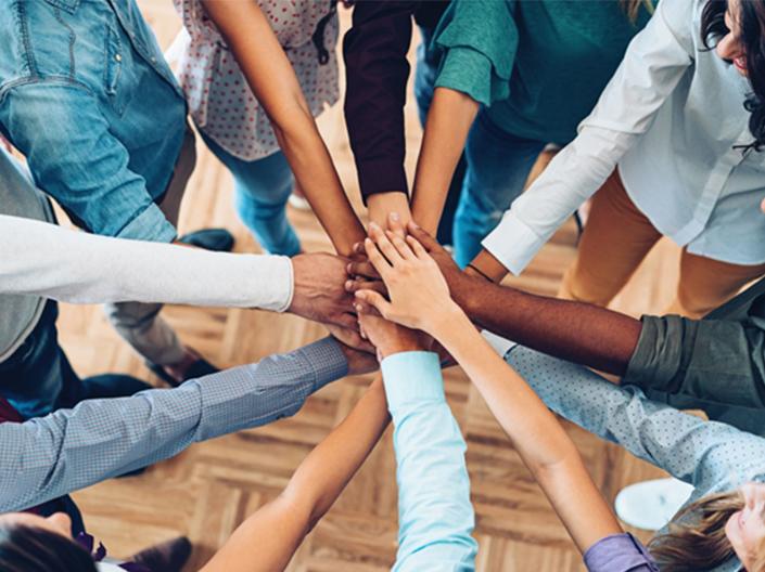 People placing hands together in group