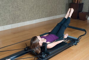 Woman using a pilates reformer machine