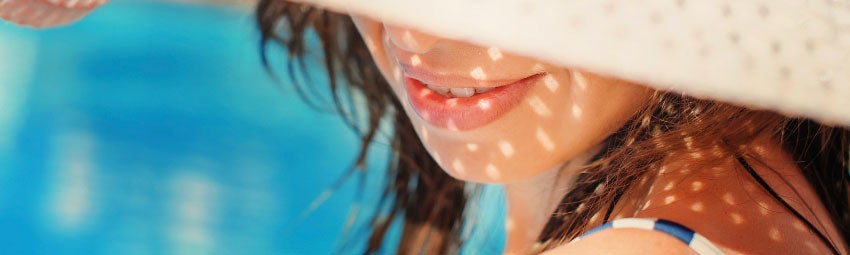 Image of a woman with half of her face covered by a sunhat
