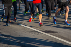 close up of men's legs and running shoes running outside on pavement
