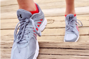 close up woman;s feet grey running shoes walking up wooden stairs