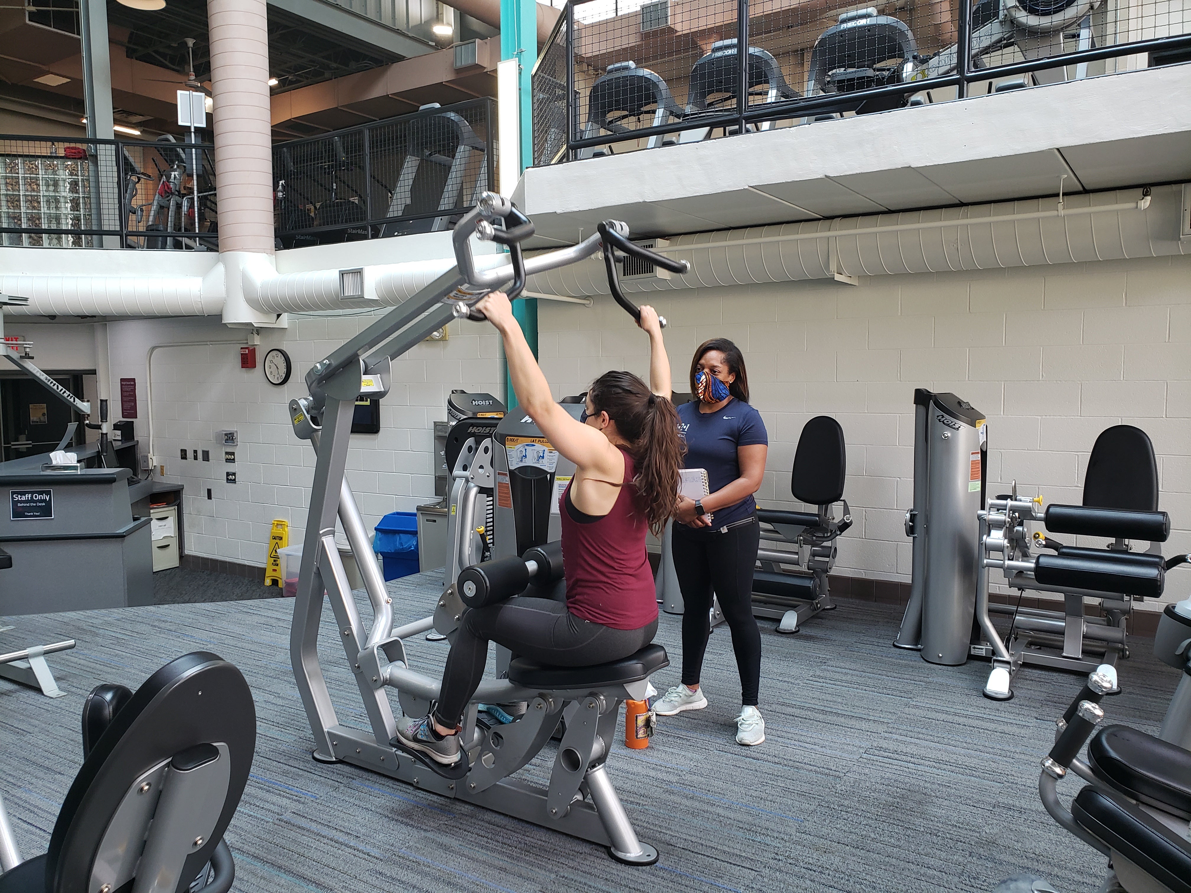 Woman personal training client on lat pulldown