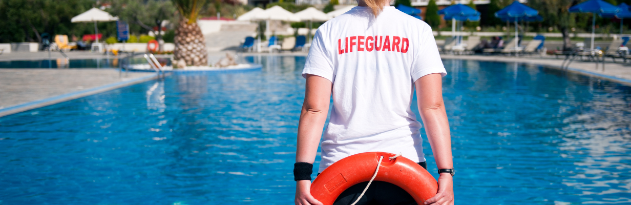 Back of Lifeguard holding a ring in front of a pool