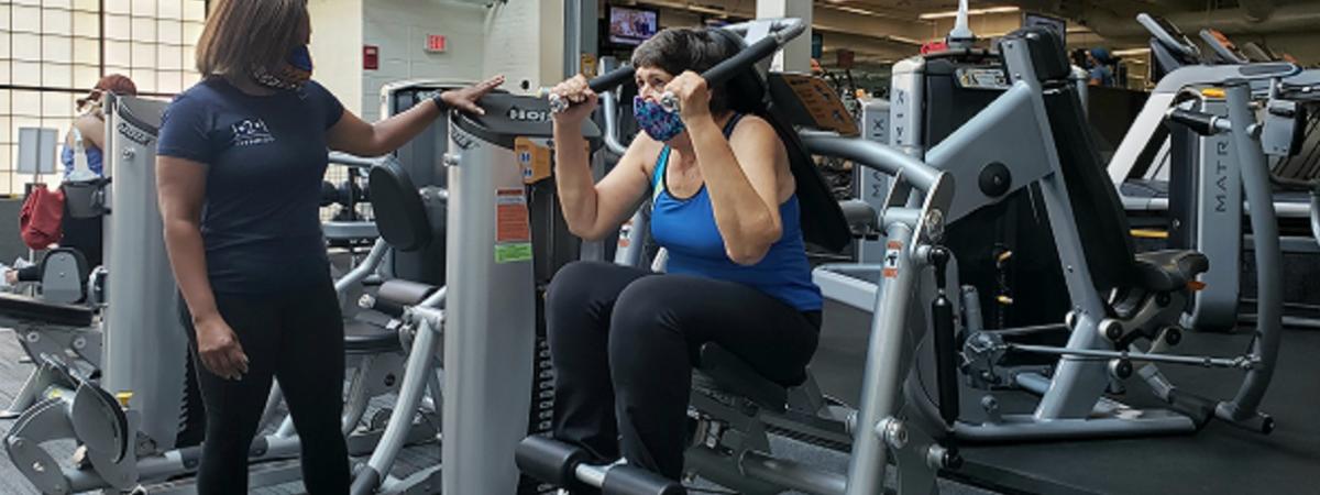 Woman personal trainer with client on ab machine