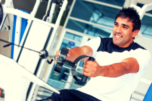 man smiling performing low row exercise on a cable machine