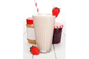 strawberry and peanut butter shake with red and white striped straw and a strawberry on the rim, peanut butter jar to the left of the shake, jelly to the right of the shake