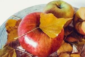 apples on a plate with fall leaves