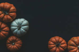 black background with small white and orange pumpkins
