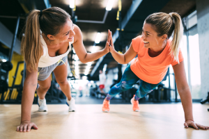 two women doing planks high-fiving