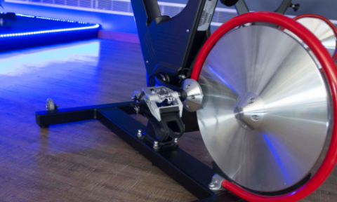 Exercise bike with silver and red wheel and blue lights in upper left corner