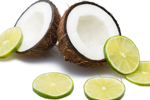 coconut split open with slices of lime around them