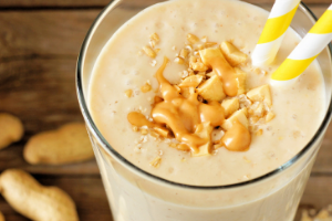close up of shake with caramel on top and two straws