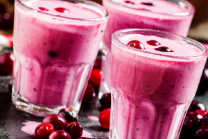 Three berry shakes with berries around them