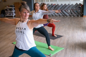 Three women in yoga pose in yoga studio
