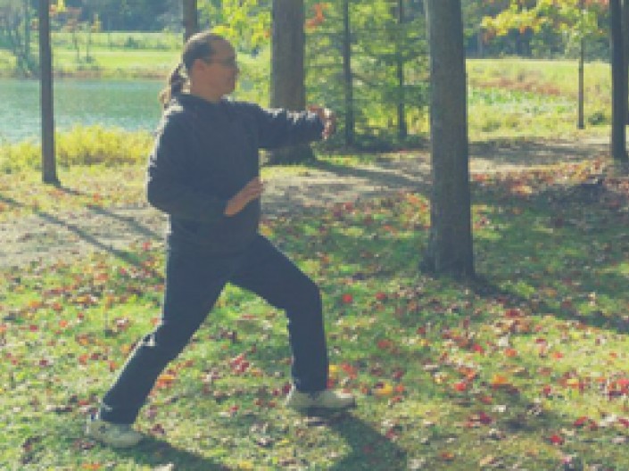 Man doing yoga outside on grass