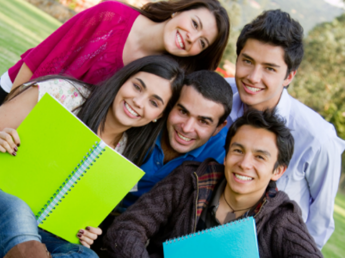 group of five college students outside with notebooks