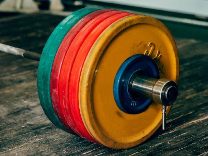 closeup of plates on barbell on floor