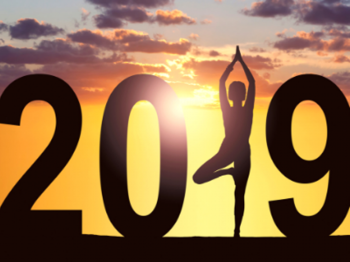 woman doing yoga pose with sunset in background forming the number 1 in 2019