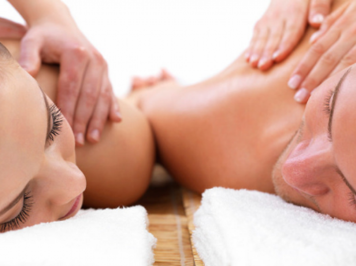 couple laying on massage tables facing each other