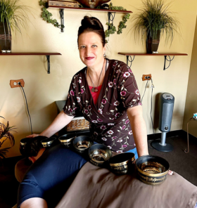 Therapist using singing bowls on man on a table