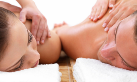 couple laying on massage tables facing each other