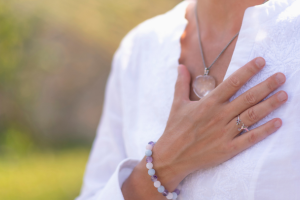 Person in white shirt with hand over heart