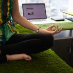 person in office sitting on a desk meditating
