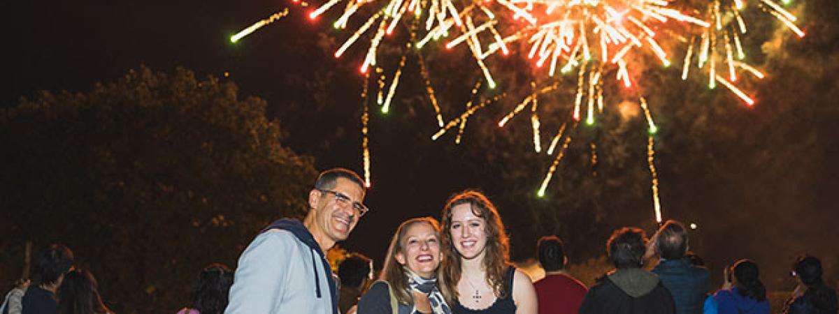 Student with their parents at a fireworks display
