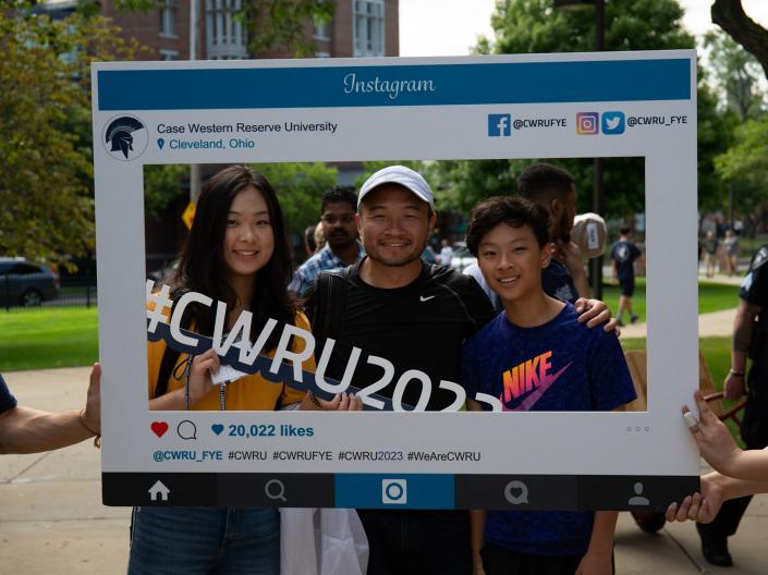 student and their family posing for a photo using an orientation Instagram frame