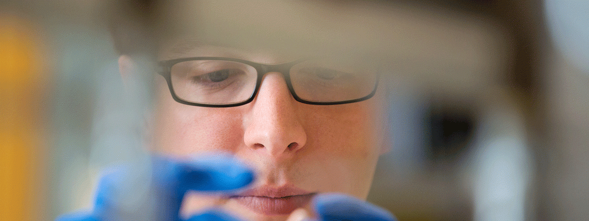 Close-up photo of student's face as the student inspects an item in a laboratory
