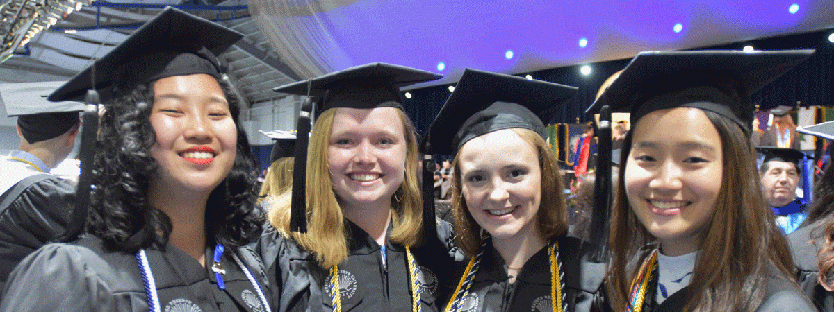 Four Case Western Reserve University students in graduation attire