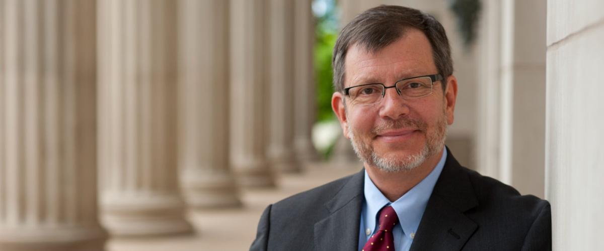Eric Kaler headshot in front of building with columns