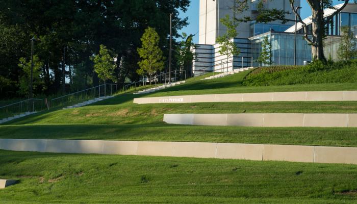 view of grassy steps on the Nord Family Greenway and a sign that says Toby's Terrace Toby's Pla