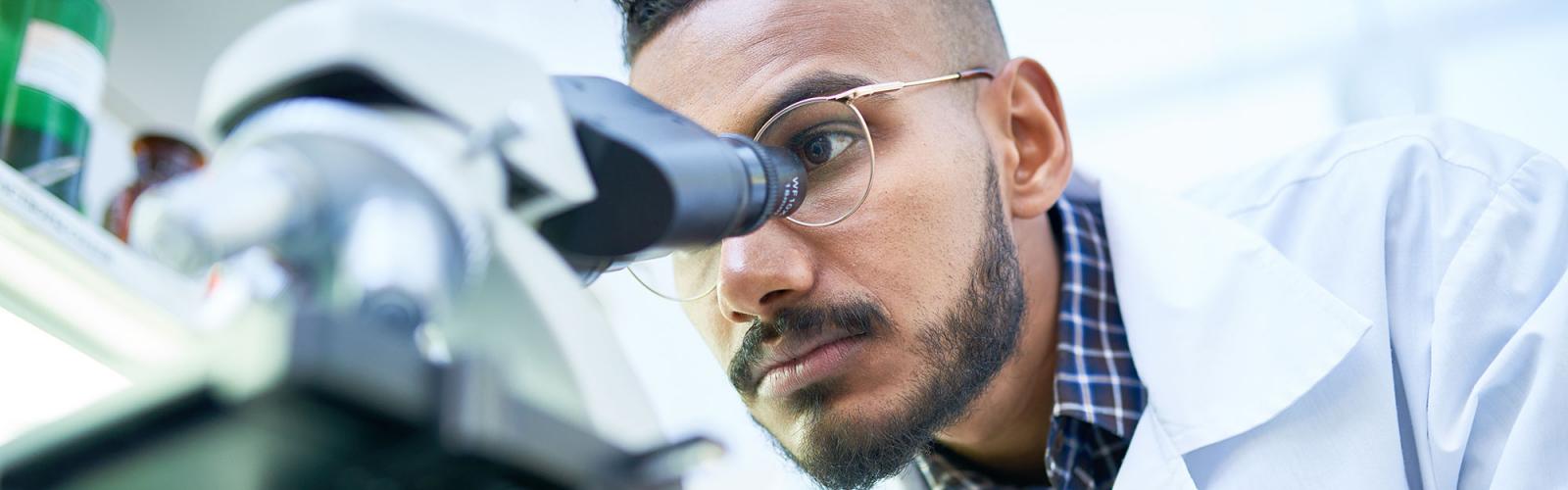A student looking into a microscope