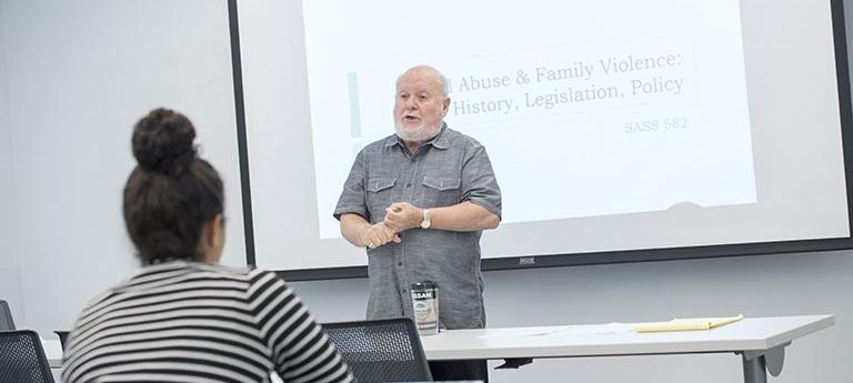 Professor speaking in lecture about abuse & family violence: history, legislation, policy