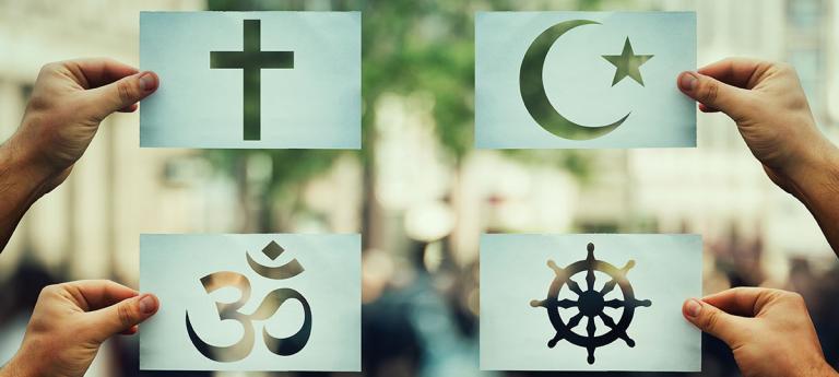 Different types of religious symbols being held up on different index cards