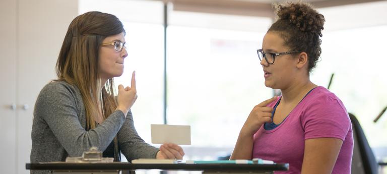 A communication sciences student working with an adult
