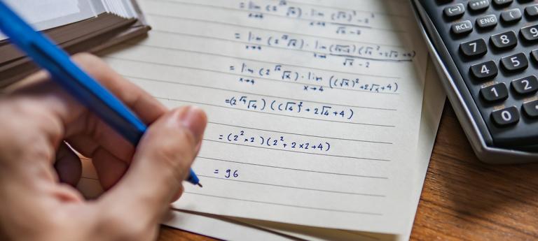 A left-handed person solving math problem