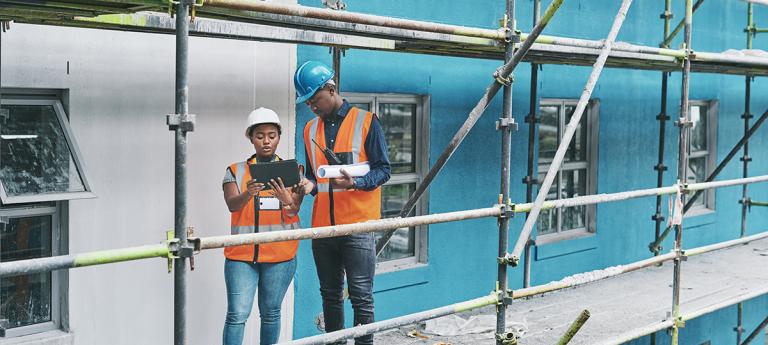 Shot of a young man and woman using a digital tablet while working at a construction site