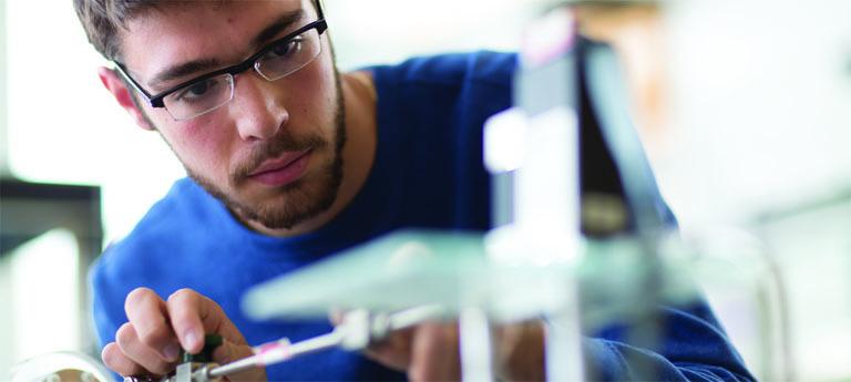Student in lab close up wearing glasses