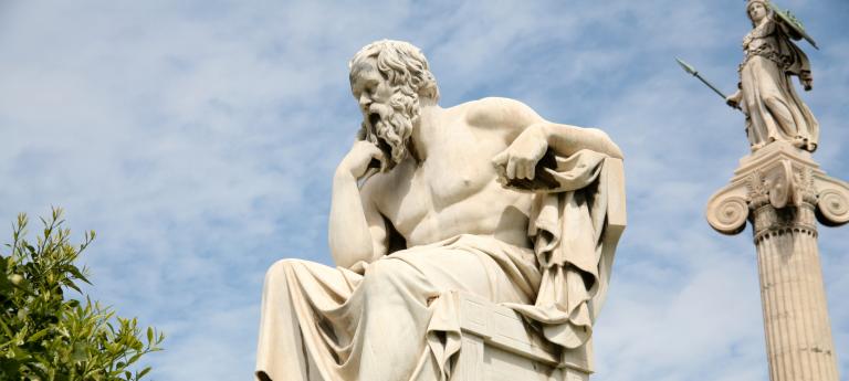 A marble statue of Socrates at the entrance of the Academy of Athens in Greece