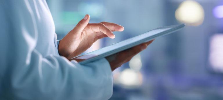 Person typing on tablet in healthcare setting