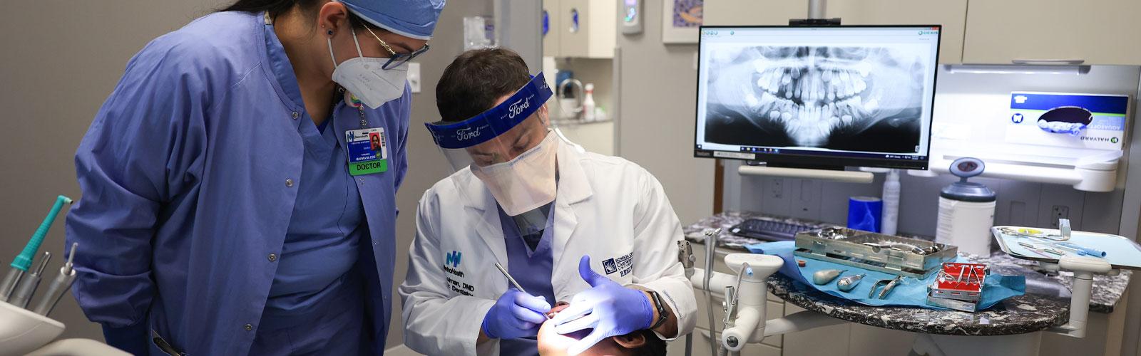Two Case Western Reserve University dental students work on a patient in the clinic