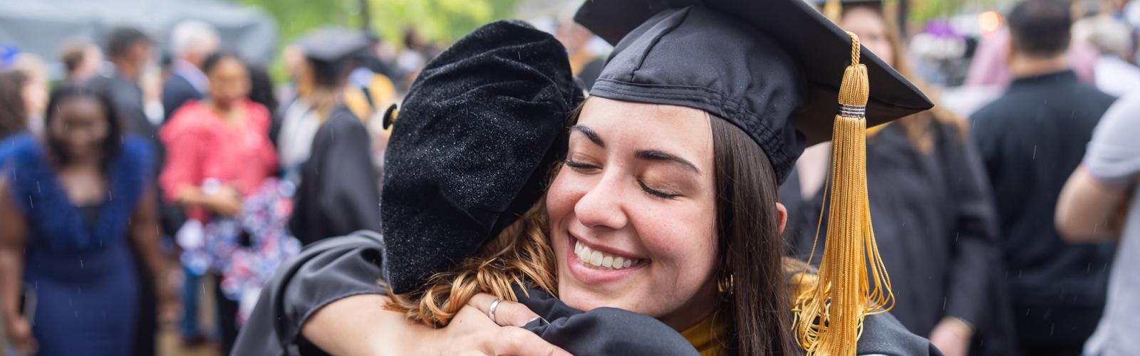 Two Mandel students hug one another at graduation