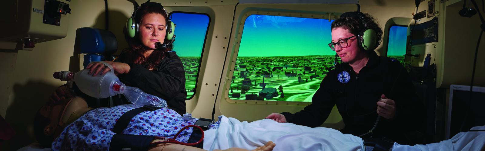 Two nursing students in the flight nursing simulator