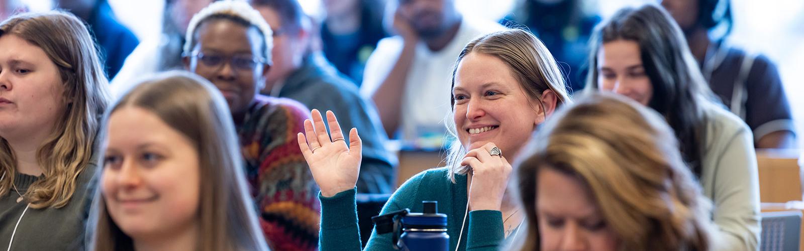 group of students at desks with one smiling at the camera