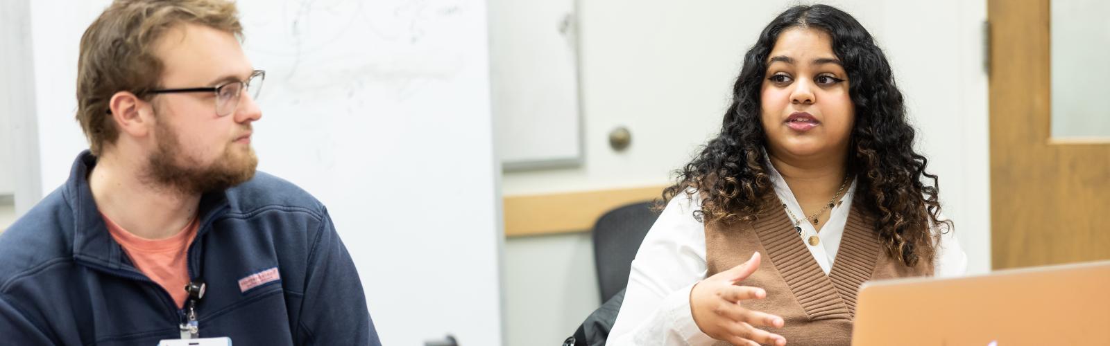 Two bioethics students discussing in a classroom