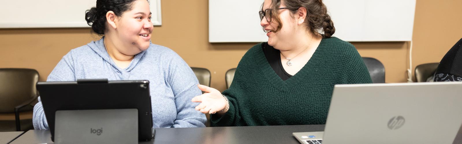 Two bioethics students talking in a classroom