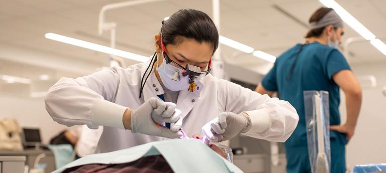A dental student working on a patient