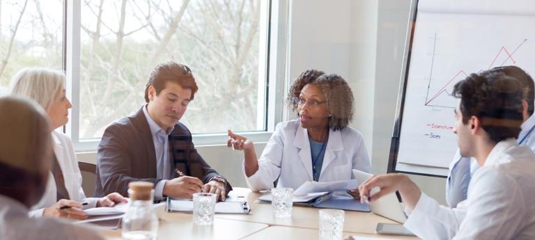 Mature doctor discusses something during conference - stock photo